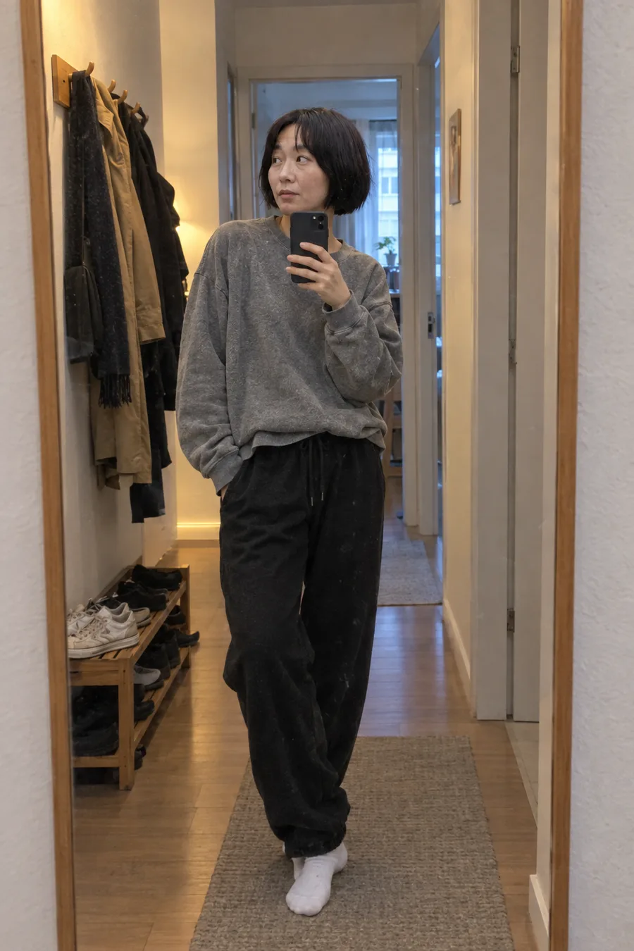 A casual mirror selfie at home in a sweatshirt and joggers